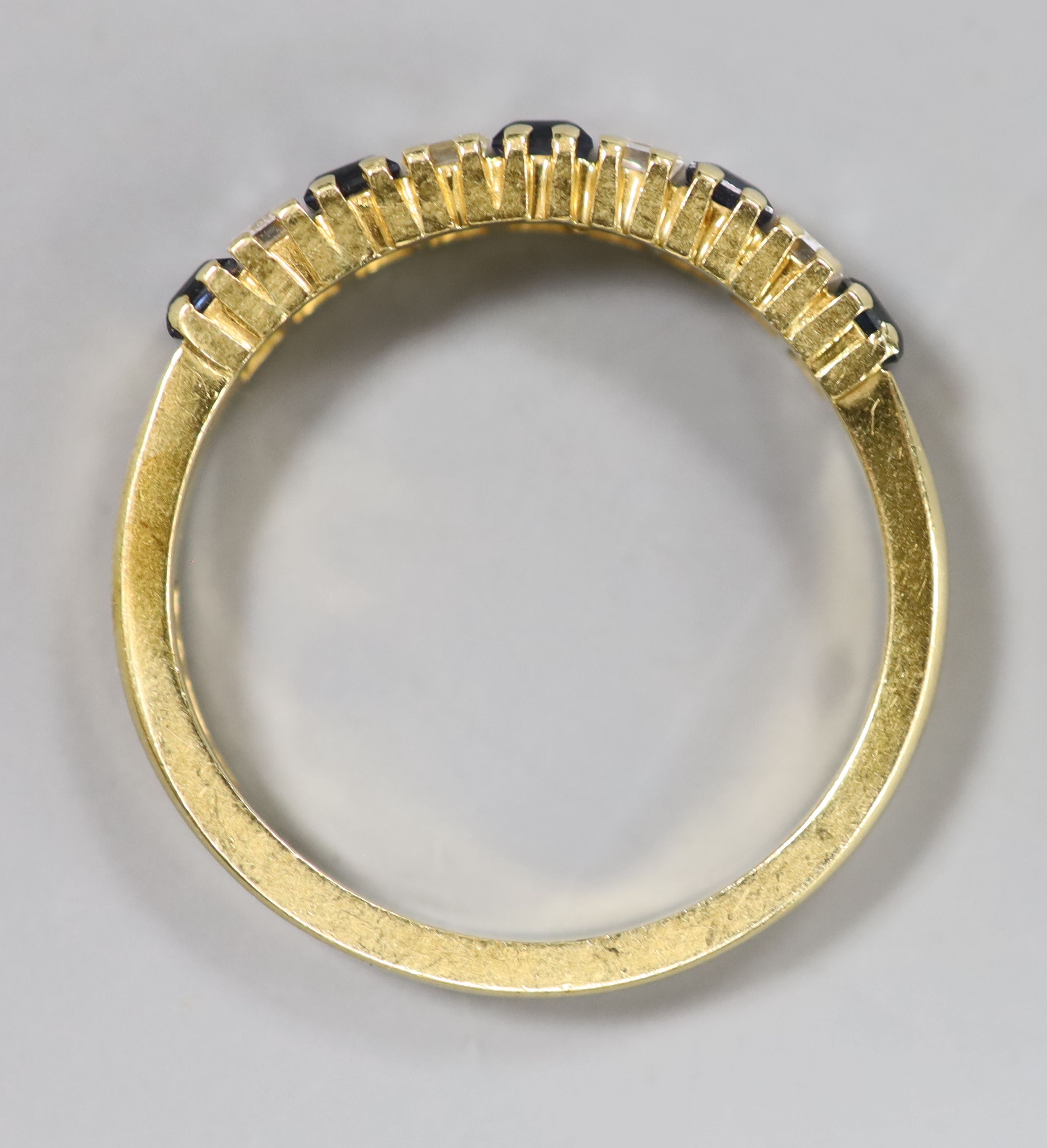 A modern 18ct gold, five stone sapphire and four stone diamond set half hoop ring, size M/N, gross 3.1 grams.